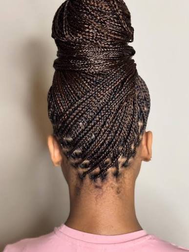 Low braided bun coiled at the nape with the ends completely tucked inside