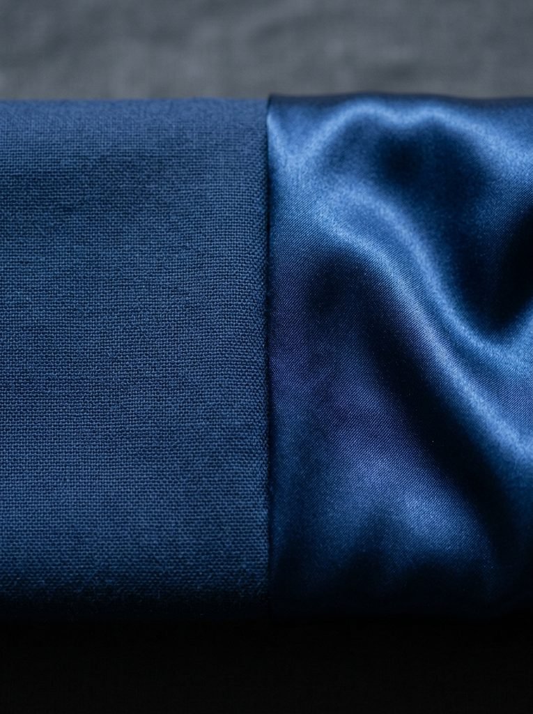 Cotton and satin fabric compared side by side in the same shade of blue to show formality differences
