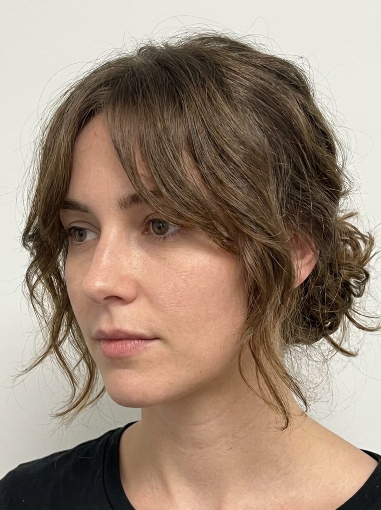 Close-up of grown-out curtain bangs at a mid-length blending stage