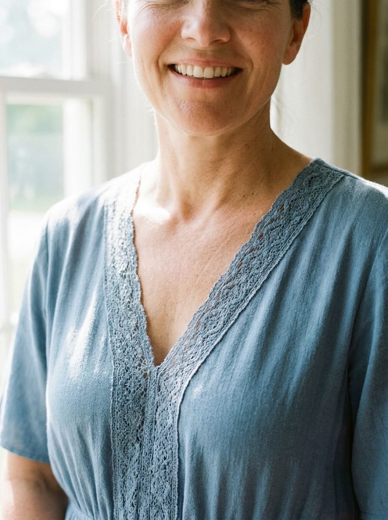 Woman wearing a V-neck dress with lace detail that opens the neckline at the collarbone