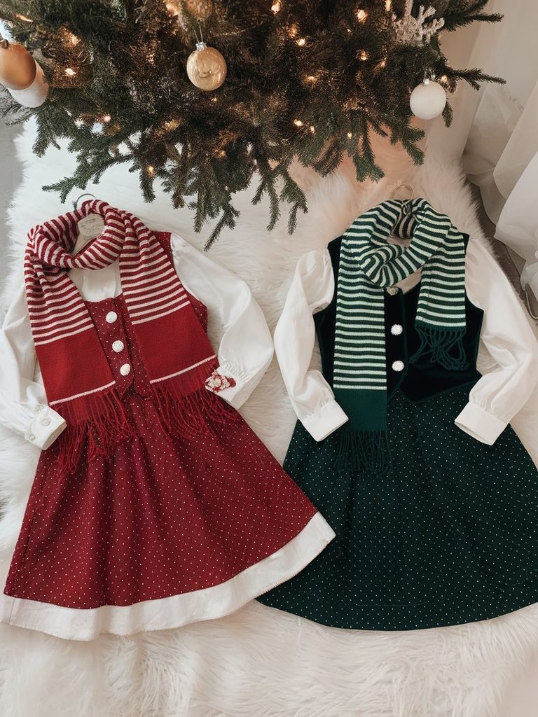 Side by side Christmas Eve and Christmas Day outfit flat lay near a Christmas tree