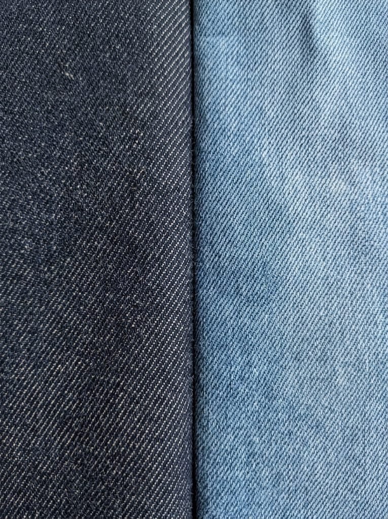 Close-up of rigid indigo denim and lighter stretch denim fabrics side by side to show texture differences